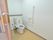 右側の壁にはL字型の手すりとティッシュペーパーが設置されておりウオッシュレットトイレを挟んで自立式の手すりもある。