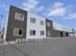 濃い茶と白で塗り分けられた箱型の2階建ての施設になっている。目の前はアスファルトの駐車場になっている。