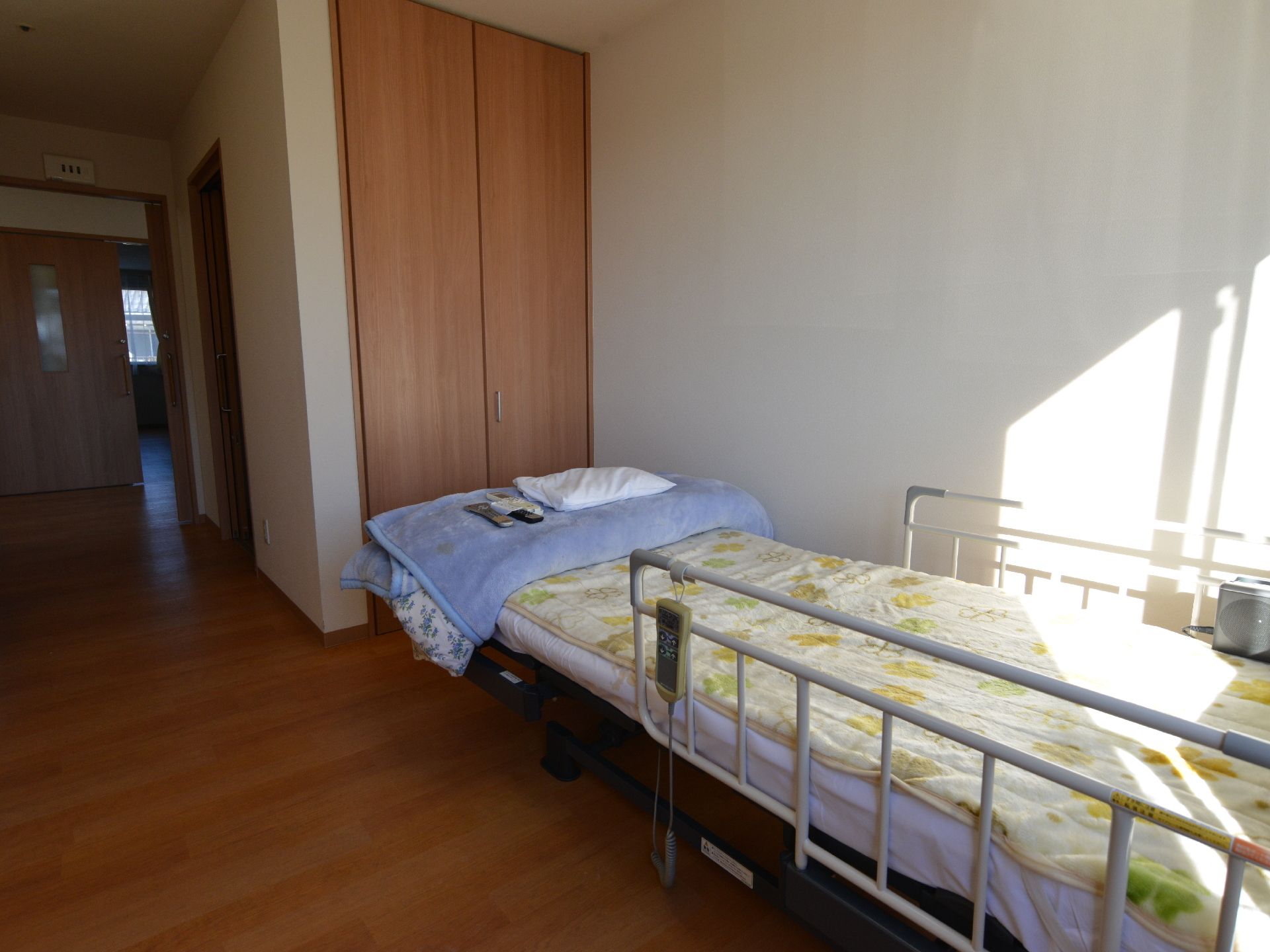 部屋の奥にベッドがある。ベッドには両脇に手すりが付いており、転落防止になっている。ベッドの脇に呼び出しベルが付いている。