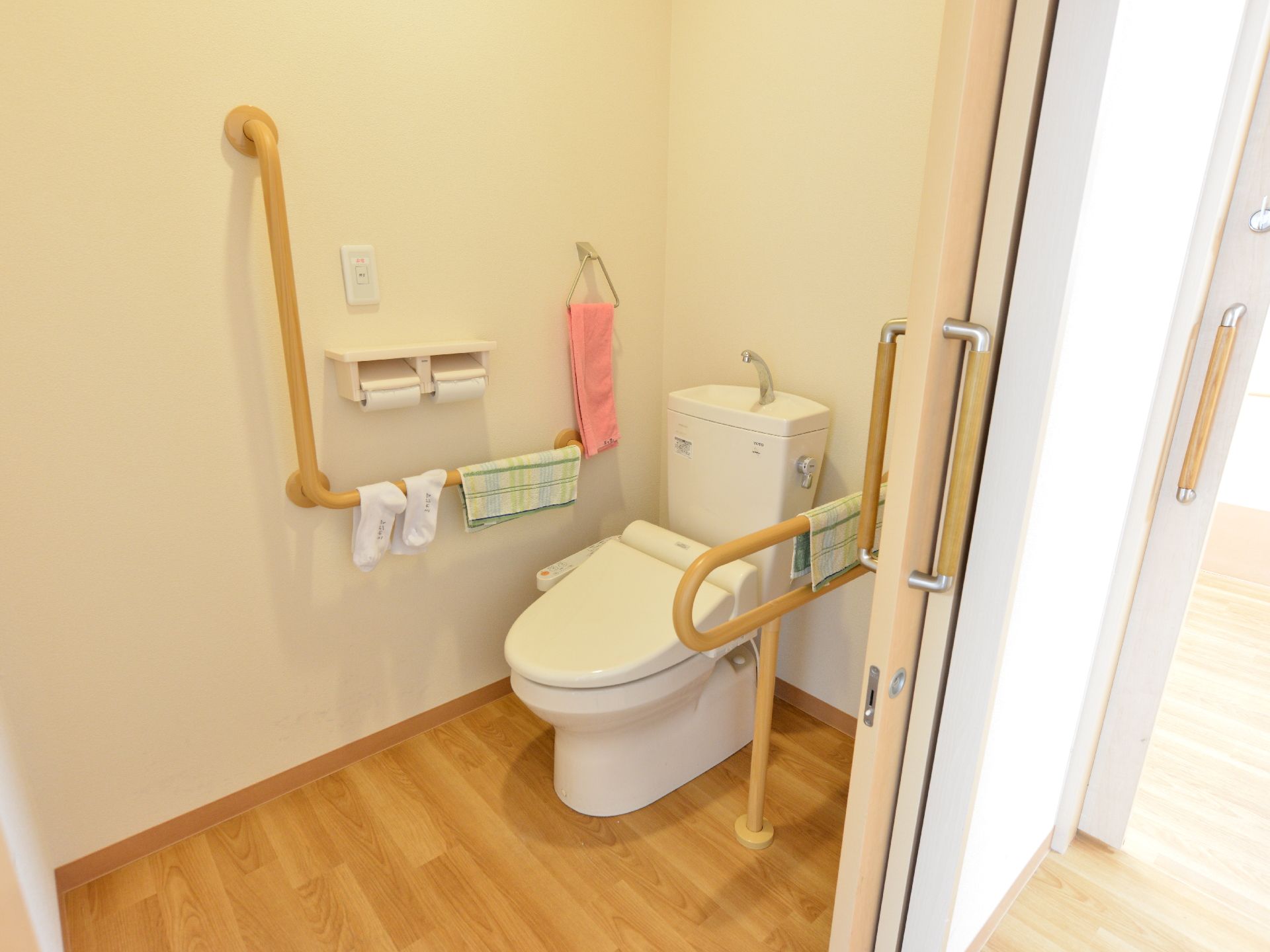 居室内のトイレは、ウォームレット式になっている。手元のスイッチで操作できる。両側には、手すりが設置されている。
