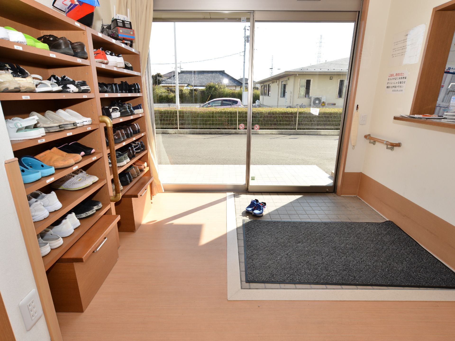 ガラス張りの自動ドアのエントランス。入って右側には、靴箱があり、左側には受付カウンターがある。上り口は段差がなくマットが敷いてある。