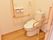 トイレの扉はスライド式で出入りがしやすい。入るとすぐに手すりがあり安心。便座の前はスペースが取られている。