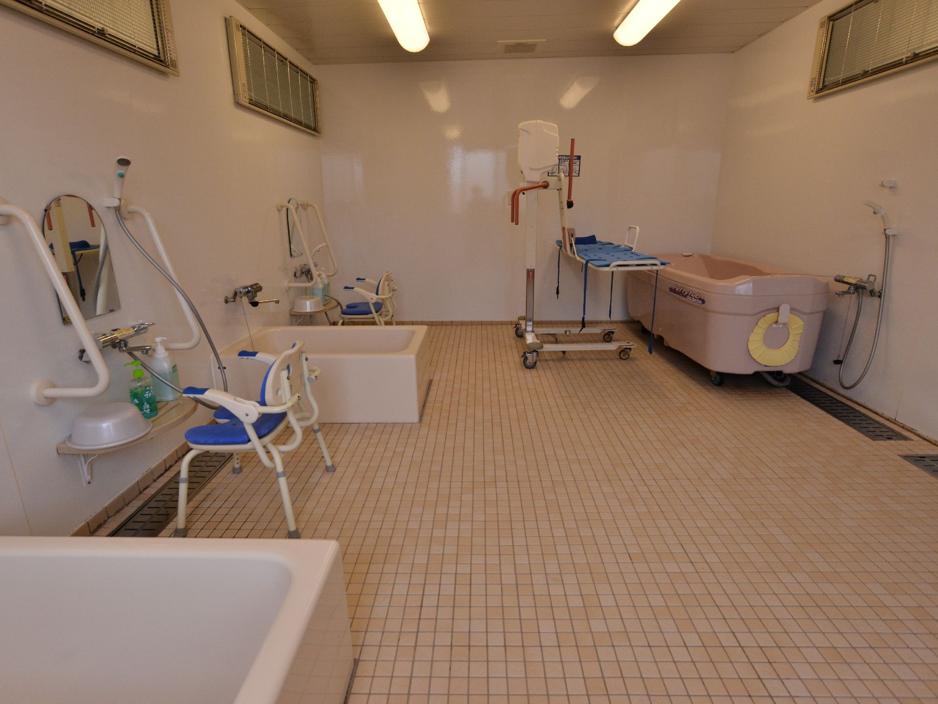 広い浴室に、ストレッチャーで入浴できるタイプの介助用入浴設備が置かれている。通常のシャワー・浴槽もあり、様々な状態の入所者に対応可能。