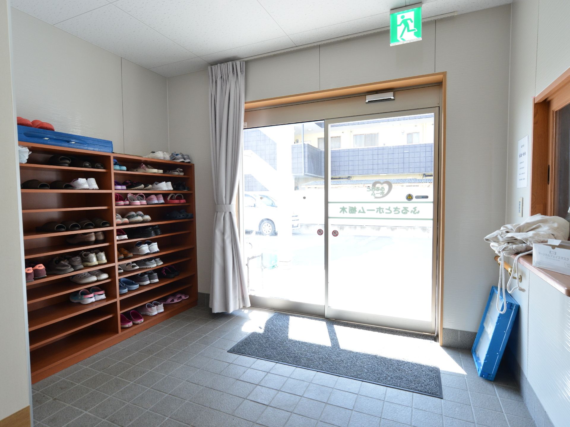 入口横に大きな靴箱がありたくさん靴が入れられる。フラットな床なのでつまずき防止になり安全である。受付がある。