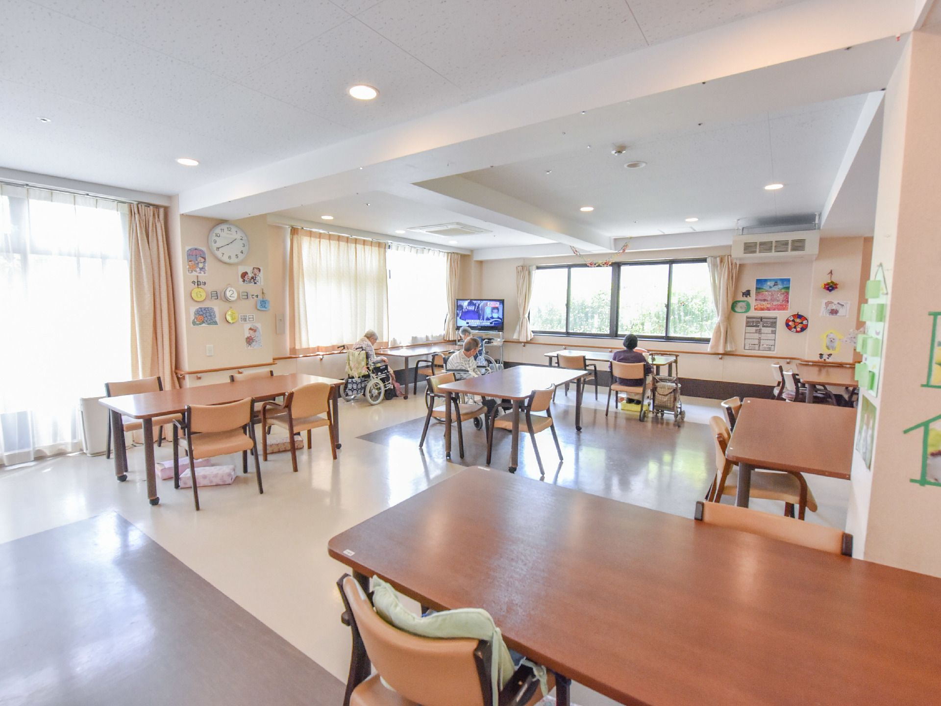 談話室には、大きなテレビが設けられていたり、スタッフや利用者が作った作品が飾られてある。窓が多くある。