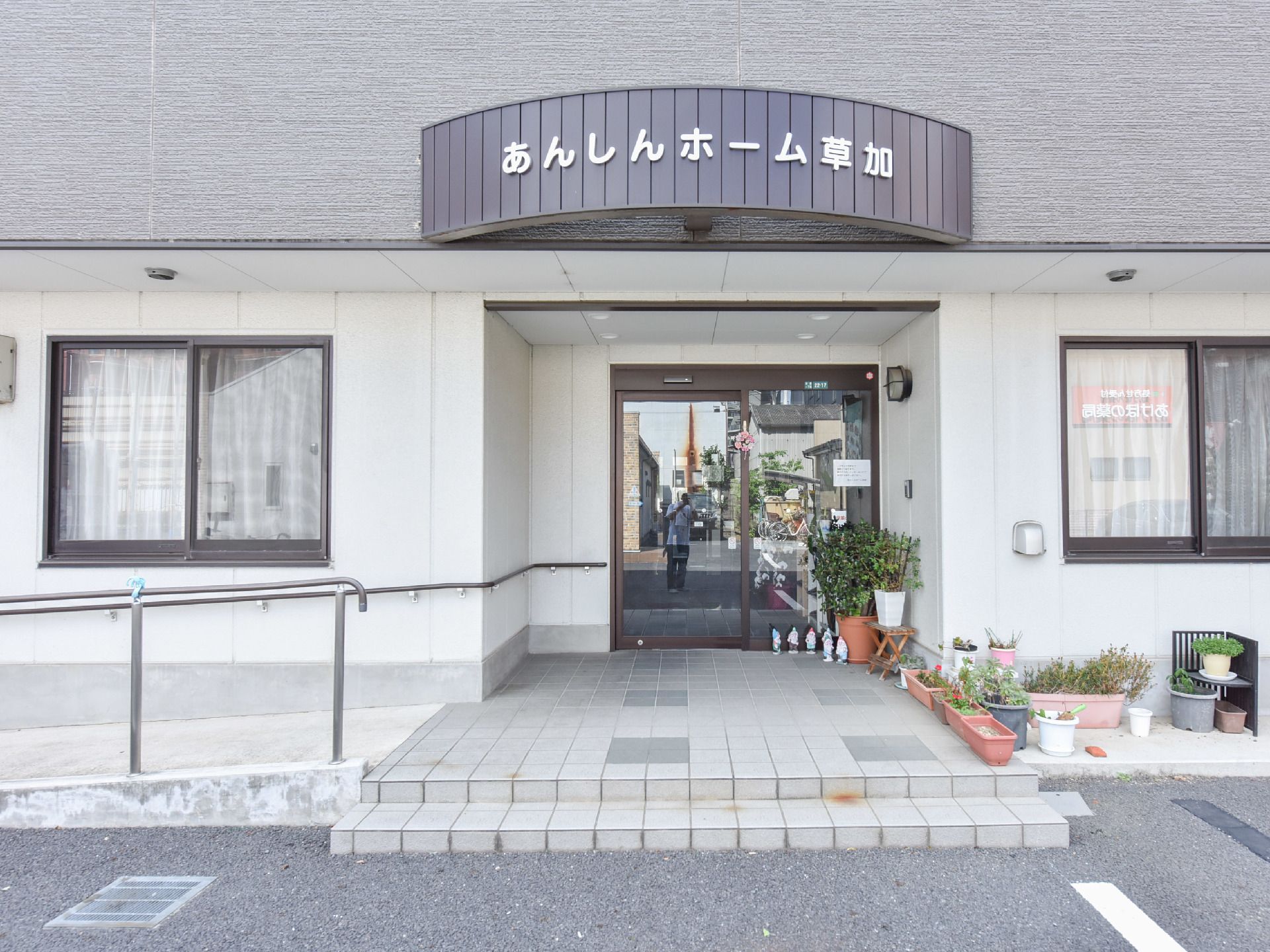 正面には、施設の看板が掲げてあるので、来訪者も迷わず訪れることができる。低い階段が高齢者でも上りやすい作りになっている。