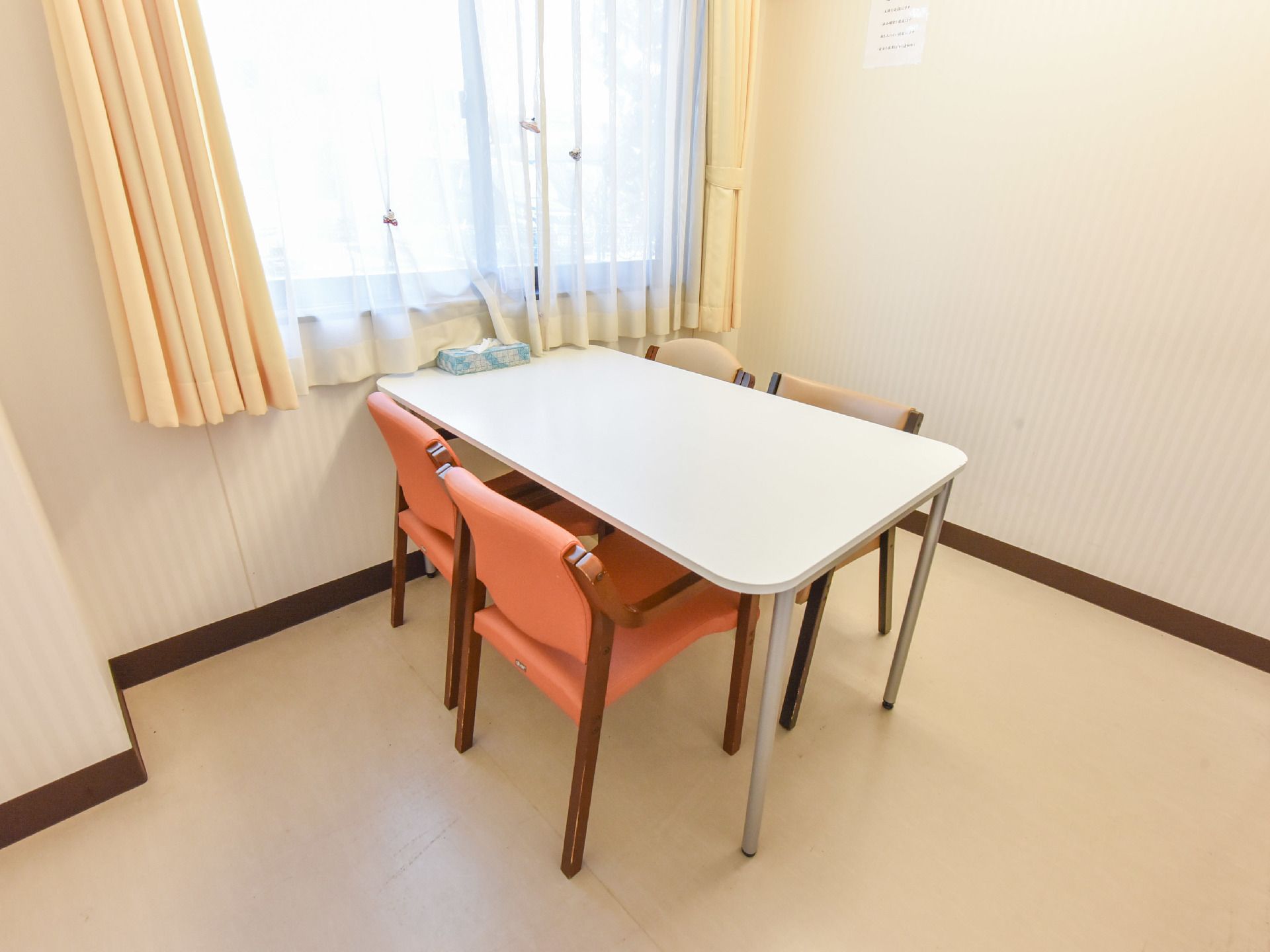 こじんまりとした机と椅子がある相談室。窓からは明るい日差しが入り心地良い。相談事やトラブルを受付けている部屋である。