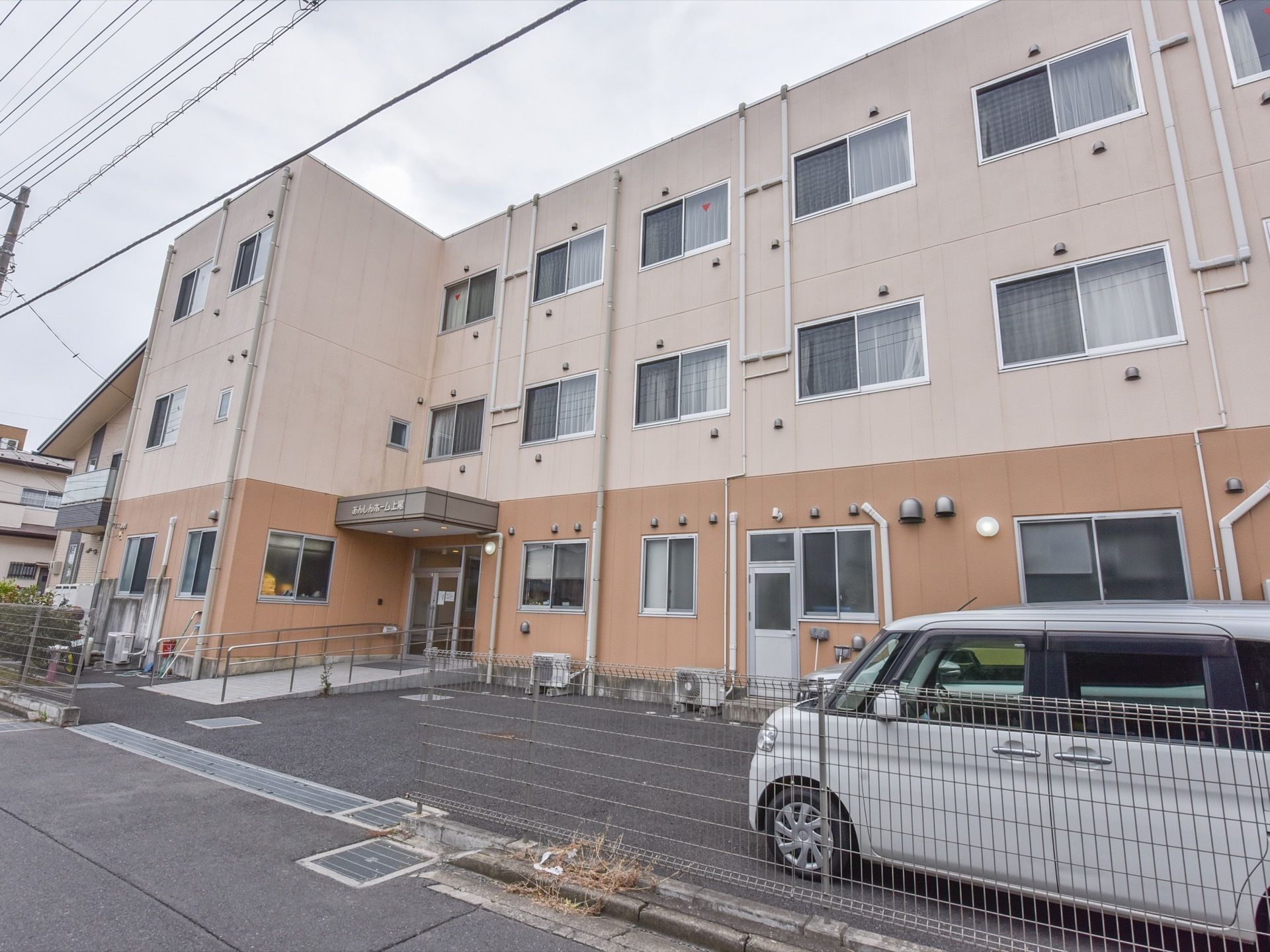 施設の外観は、建物の１階部分はオレンジ、２・３階はベージュ色のツートンカラーである。施設にはスロープを上って入る。
