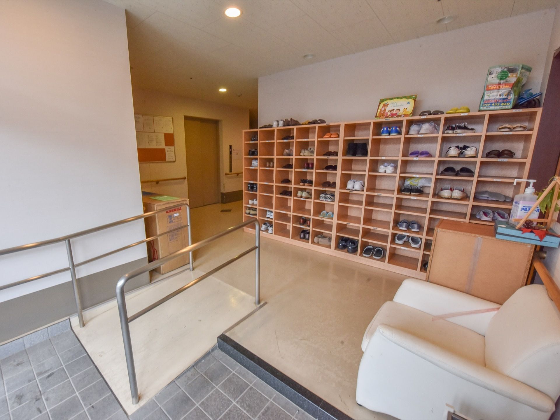 玄関に置かれている下足入れは、80足ほど収納可能である。下駄箱の向かいにあるカラーボックスの上には消毒薬が置かれている。