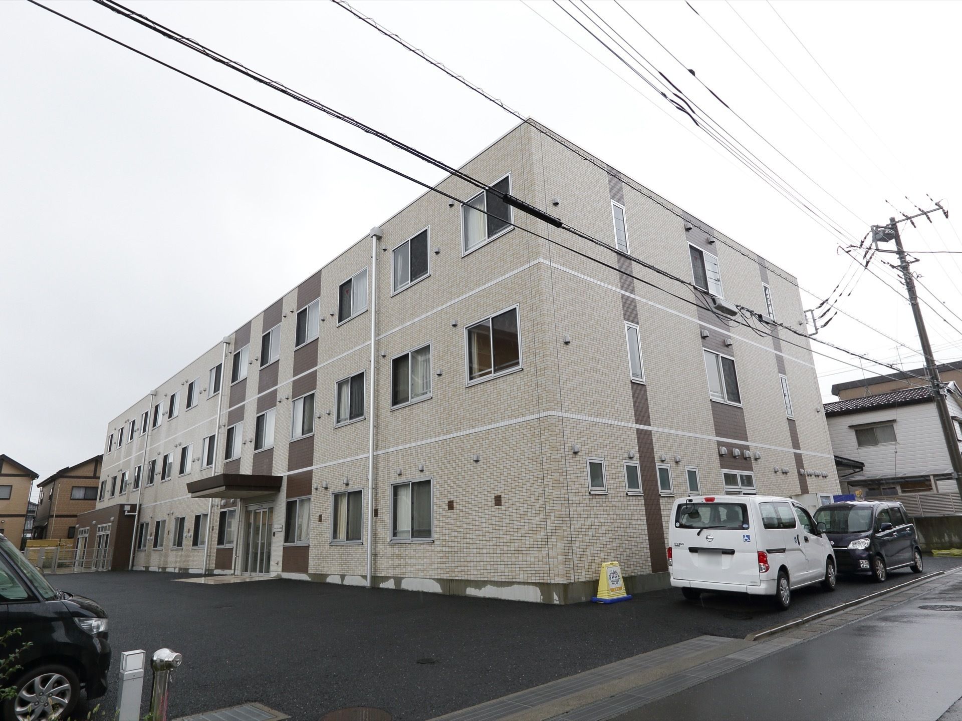 ３階建ての白い大きな建物。周辺は駐車場でエントランス前は広い空間がありバリアフリー構造である。メイン道路に面している。