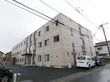 ３階建ての白い大きな建物。周辺は駐車場でエントランス前は広い空間がありバリアフリー構造である。メイン道路に面している。