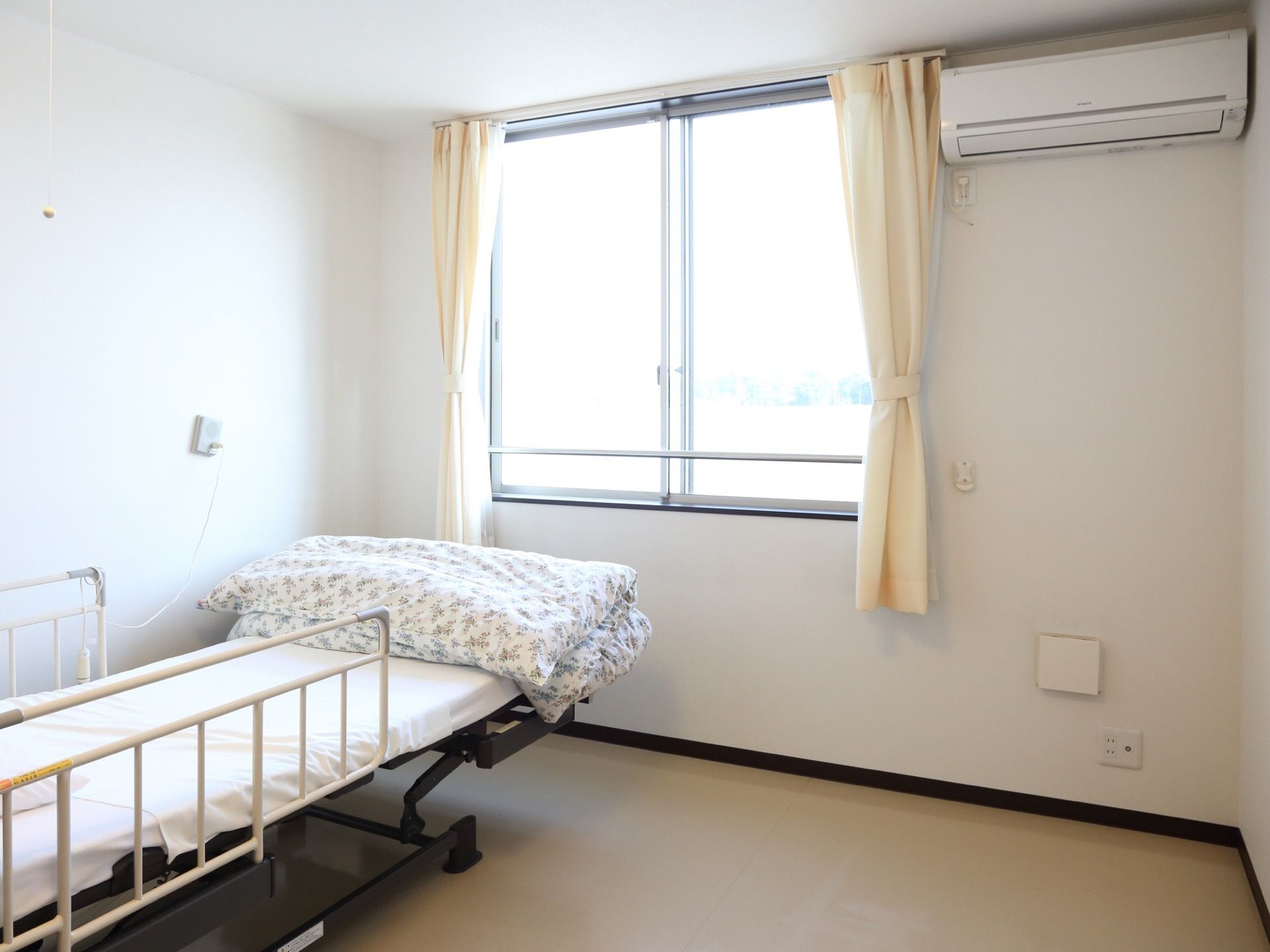 居室にはリクライニング機能のある介護ベッドを設置してある。またすぐ手の届くところにナースコールも取り付けられている。