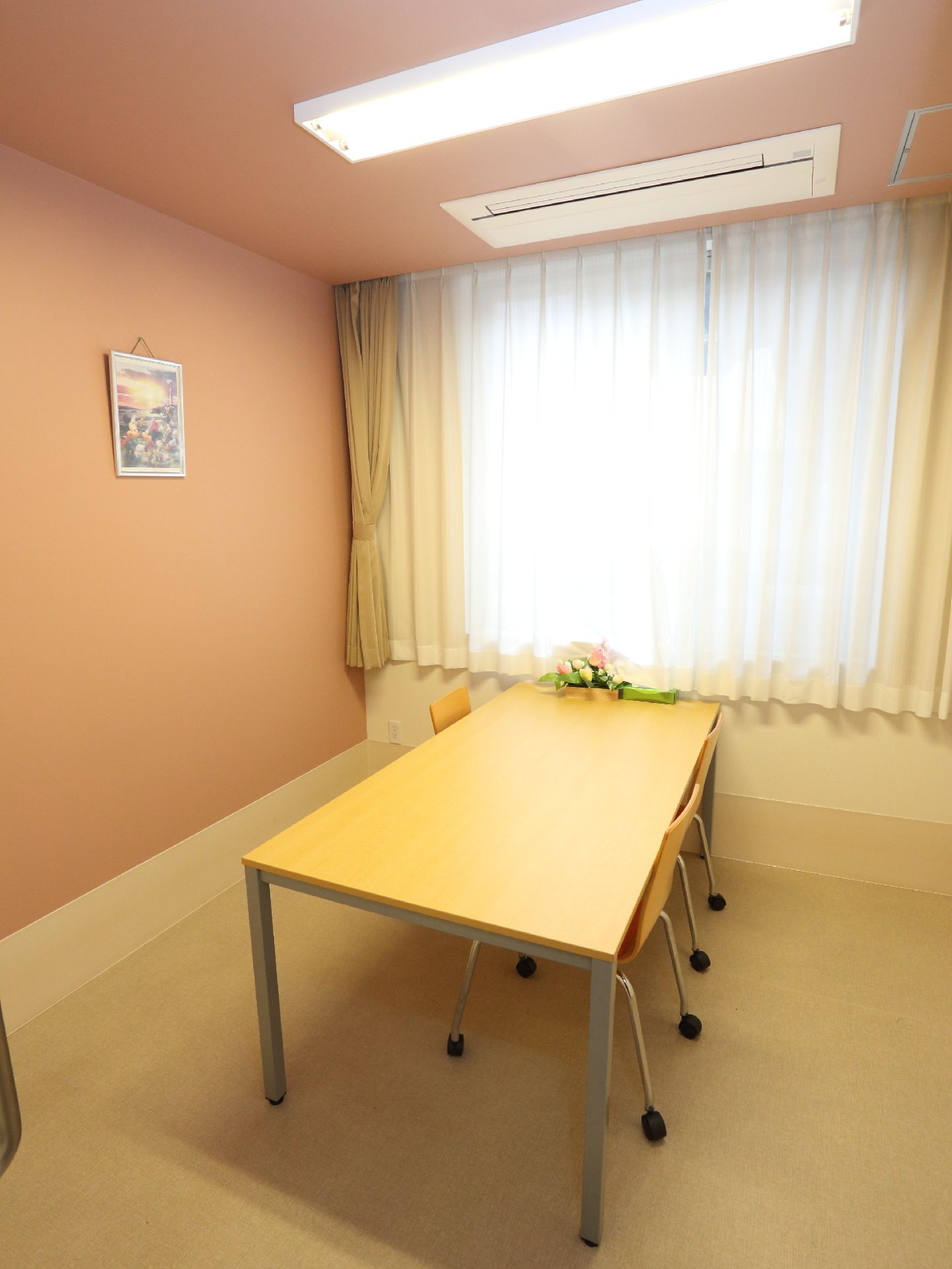 内装がピンクの相談室。真ん中にテーブルと椅子が置かれている。