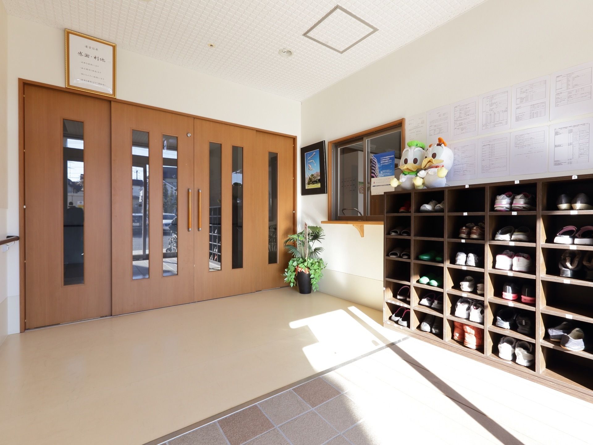 広々とした玄関の壁の前には、扉のない大型の靴箱が設置されている。床は段差のないバリアフリーになっている。