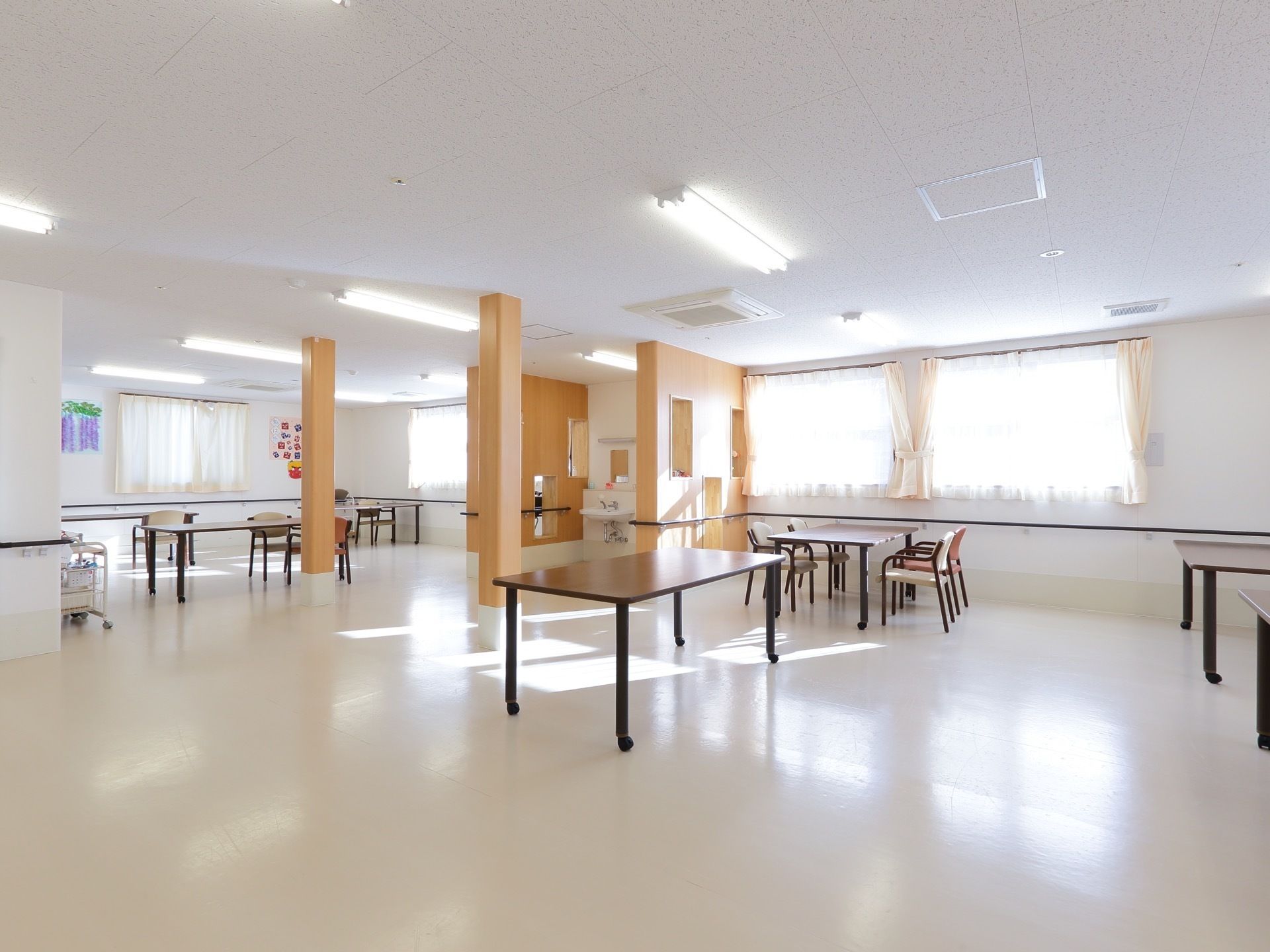 広い空間にテーブルセットが複数ゆったりと配置されている。大きな窓が複数あり、とても開放的で明るい空間になっている。