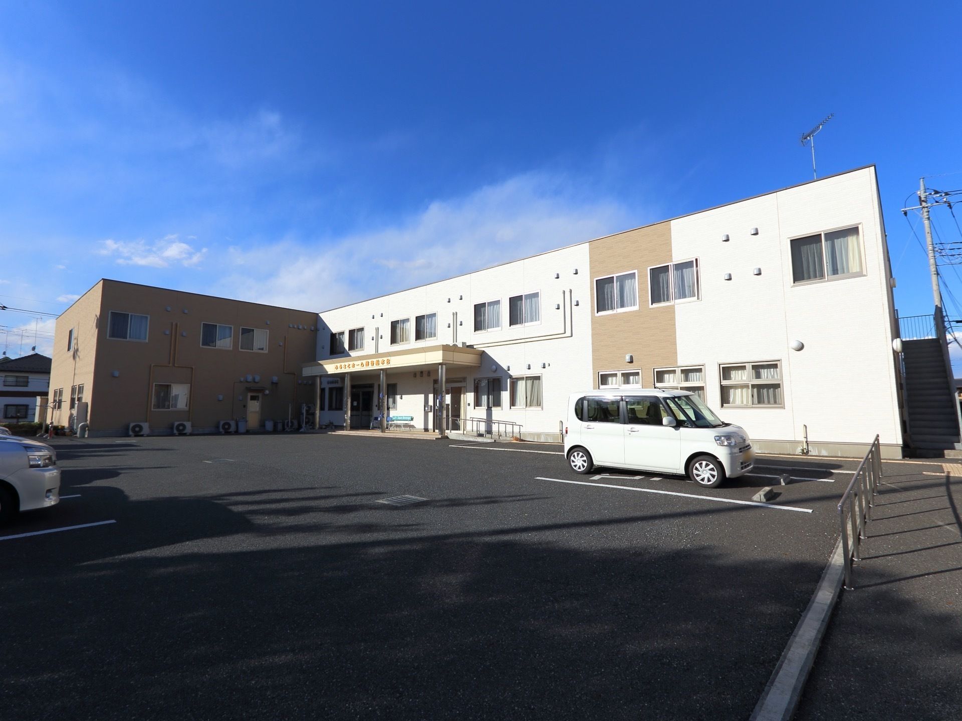 建物前には舗装された複数停められる駐車場があり車椅子専用スペースもある。駐車場と歩道を縁石や手すりで分けている。