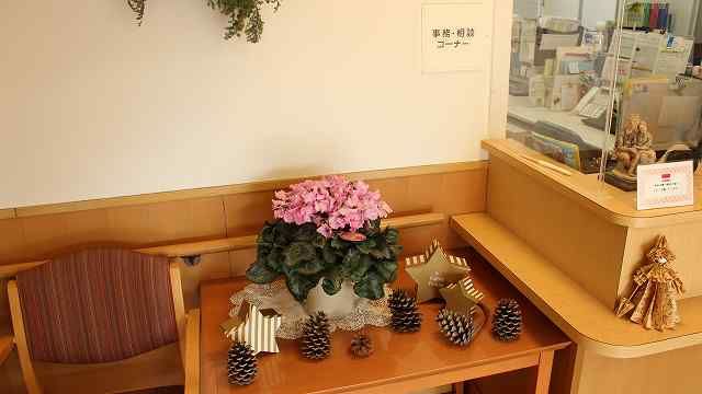 淡く明るい茶色のカウンターが設けられ、内部の様子を伺うことができる開放的な受付である。側にはサイドテーブルや椅子が備わっている。