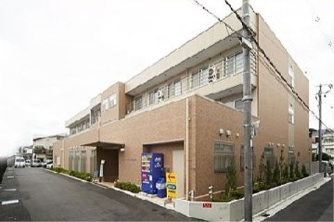 住宅街に位置するマンション風の外観で、3階建ての建物である。フラットな作りの入り口横に自動販売機が設置されている。