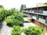 3階建ての建物と、周囲に緑が多く植えられているエントランス