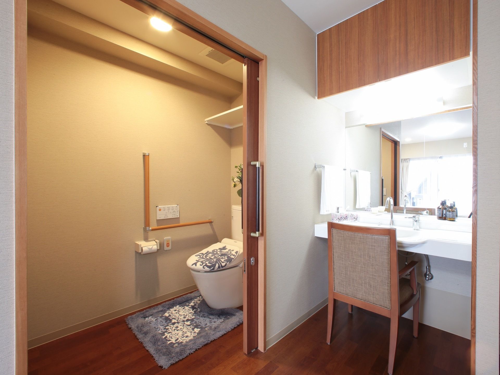 扉が大きく開くトイレと、椅子が置いてある洗面スペース