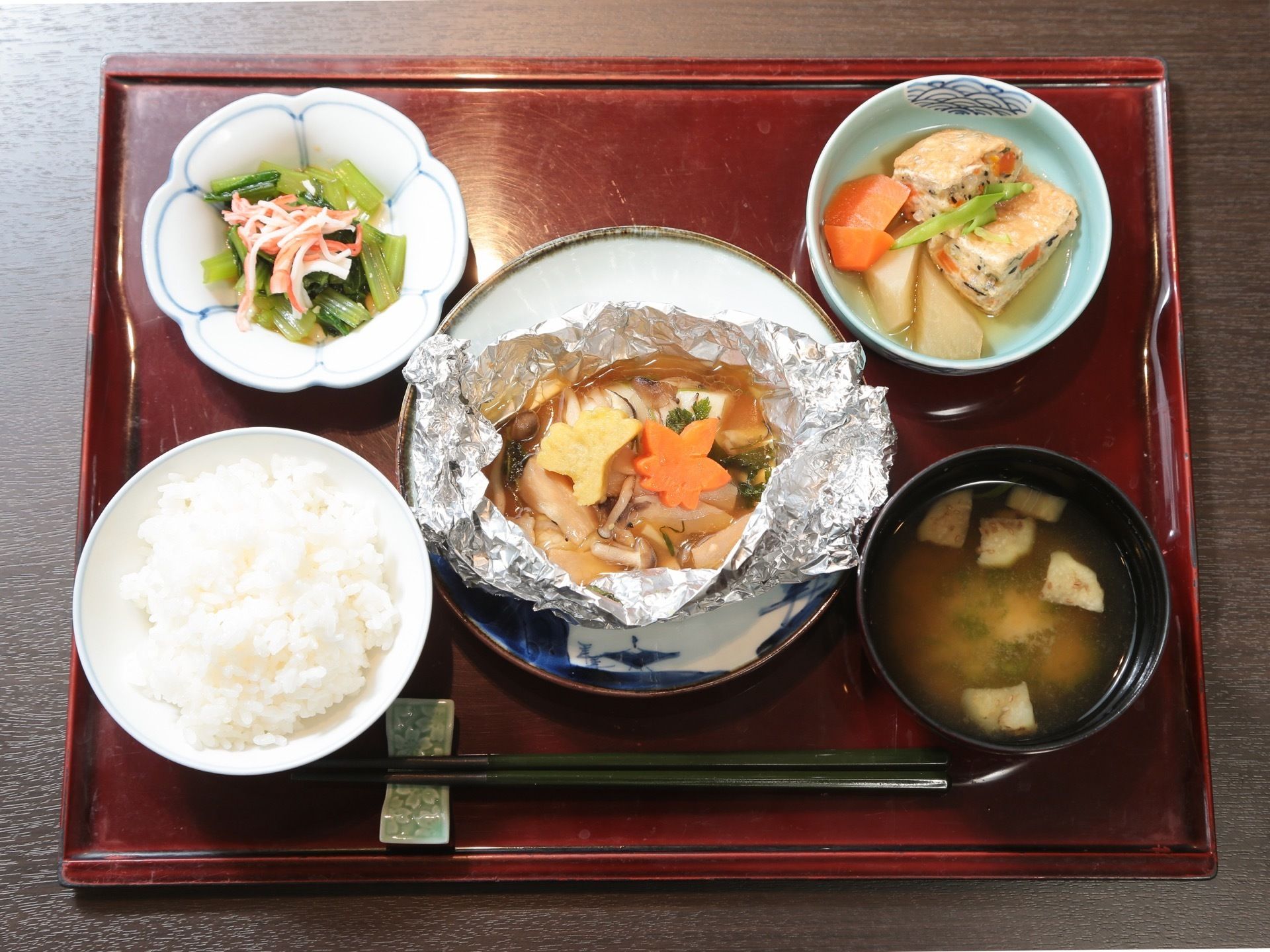 木のお盆に乗ったご飯と味噌汁、３種類の副菜、箸置きと箸