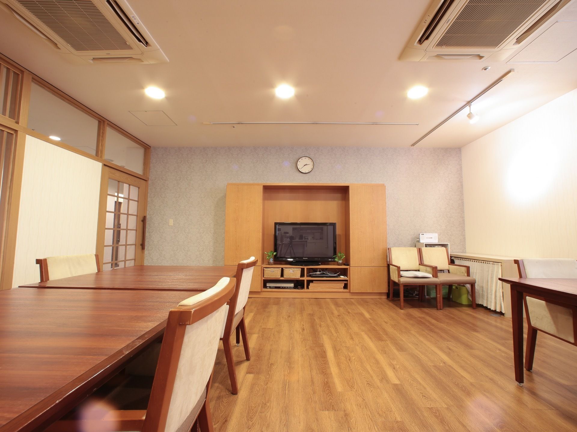 木製の大きなテーブルと椅子があり、テレビも見れる広々とした談話室