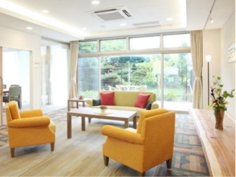 エントランスは広々としており、黄色や黄緑色のソファが用意されている。奥は、全面ガラス張りの大きな窓が取りつけられている。