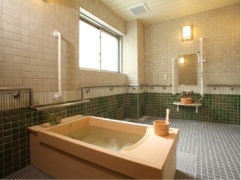 浴室は全面タイル張りとなっており、左側には木の浴槽が設置されている。壁には、手すりが取りつけられている。