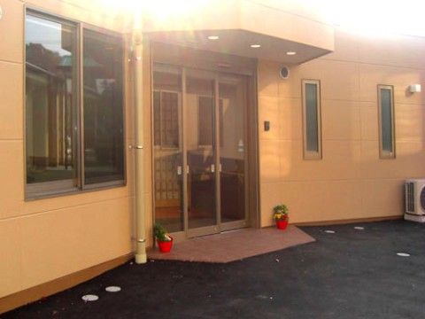 建物入口に取り付けられた庇つきの全面ガラス張りの大きな自動扉