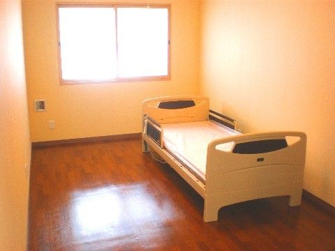 転落防止柵のついたベッドが壁際に置かれている一人用居室