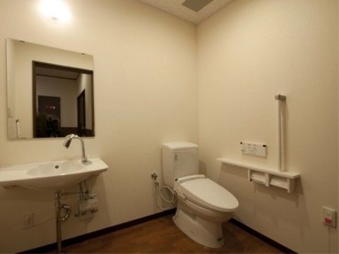 自動水栓がついた洗面台が便器の横に設置されているトイレ