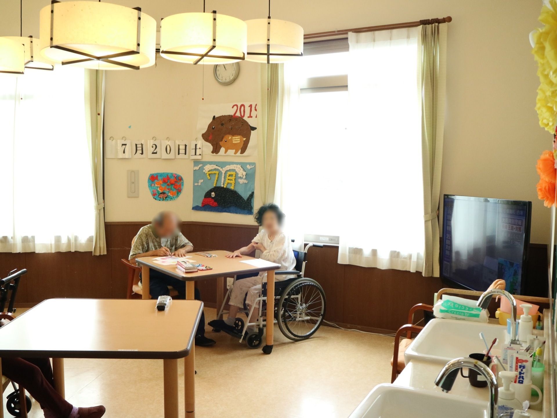 床はフローリングで、車椅子をご利用の方も移動しやすくなっている。小さな正方形のテーブルが設置されている。