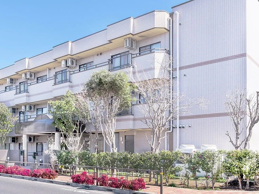 施設は鉄骨造りの３階建てで、玄関ポーチが設置されている。建物の前には植栽があり、１階部分の目隠しの役割も果たしている。