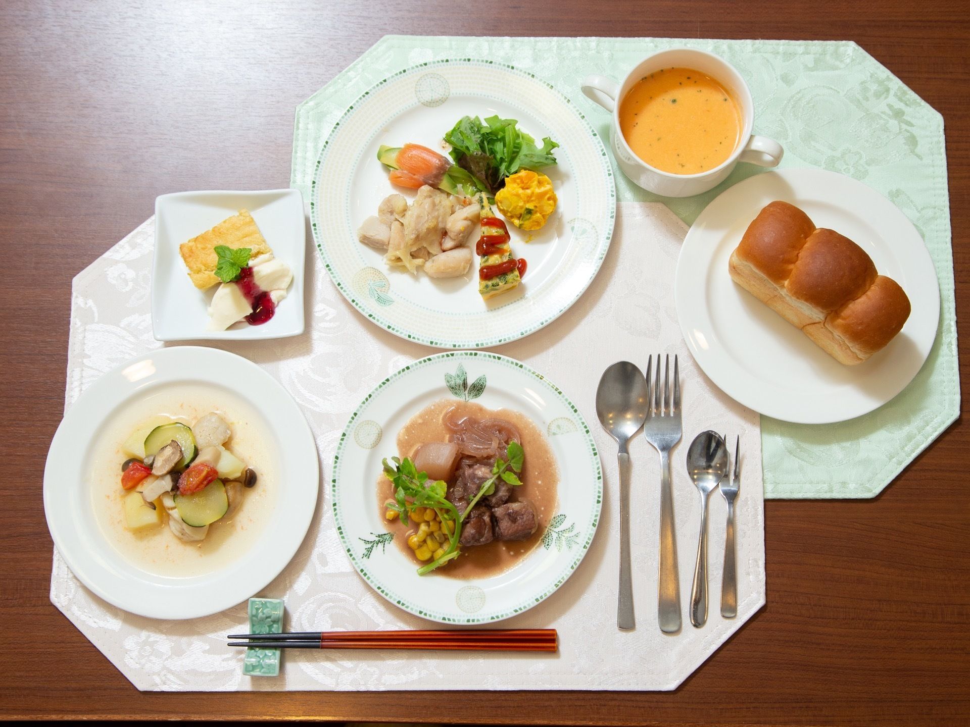パン、スープ、主菜、副菜、デザートが並ぶ多品目の食事