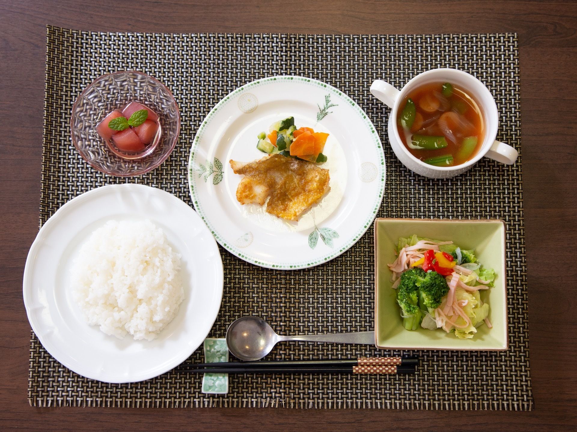 ご飯、サラダ、スープ、魚のムニエルとデザートが付いた食事