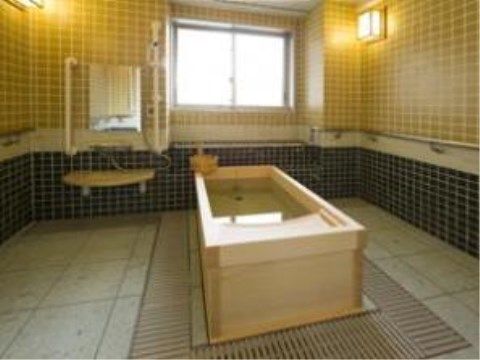 檜風呂の手前側には曲線を描くように檜の板材がカットされており、入居者様はそこに頭を乗せて楽に入浴することができる。