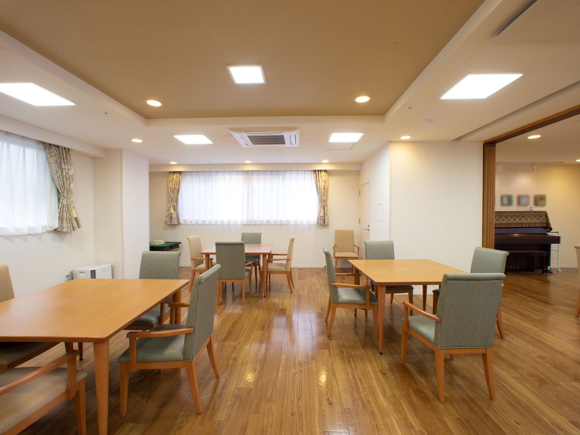 4人用のテーブルがたくさん並べられたダイニングルーム