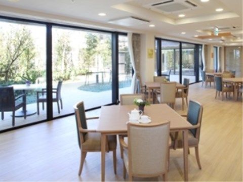 広々としたダイニングルーム兼機能訓練室には、高級感のある４人掛けダイニングテーブルが並べられている。