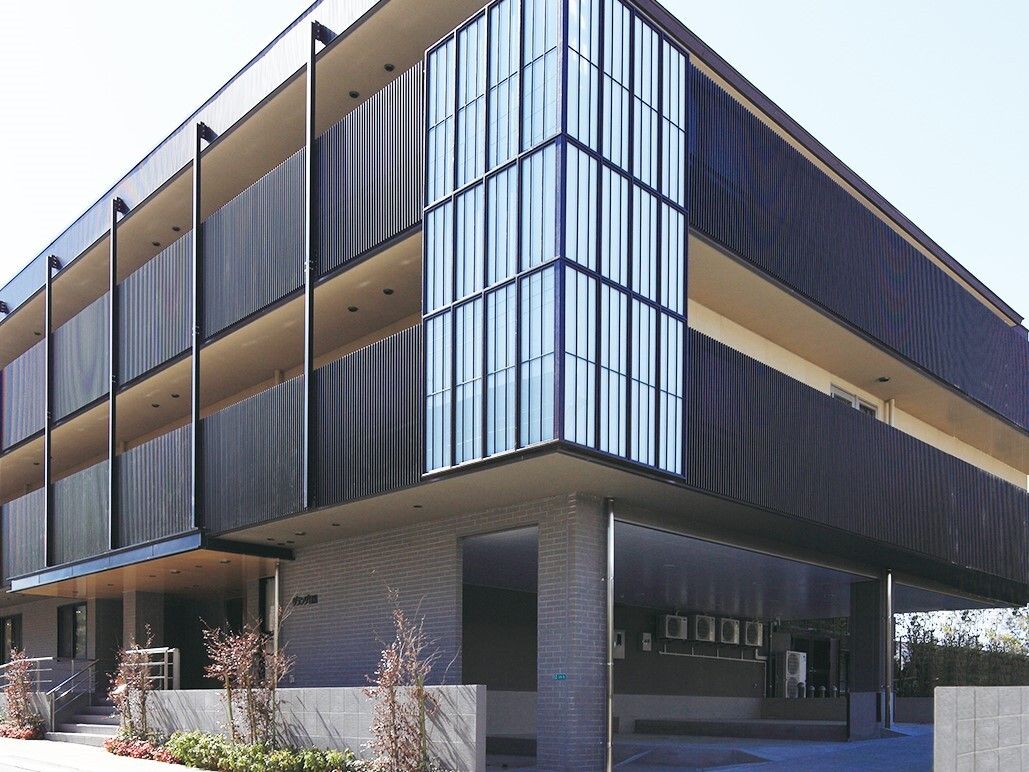 施設はモダンなデザインの３階建ての建物である。２階と３階にはバルコニーが設けられており、目隠し用の柵が設置されている。