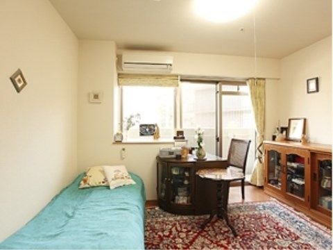 床には豪華なじゅうたんが敷いてあり、カフェテーブルや飾り棚がある。花瓶には花が活けてあり、明るい雰囲気の部屋である。