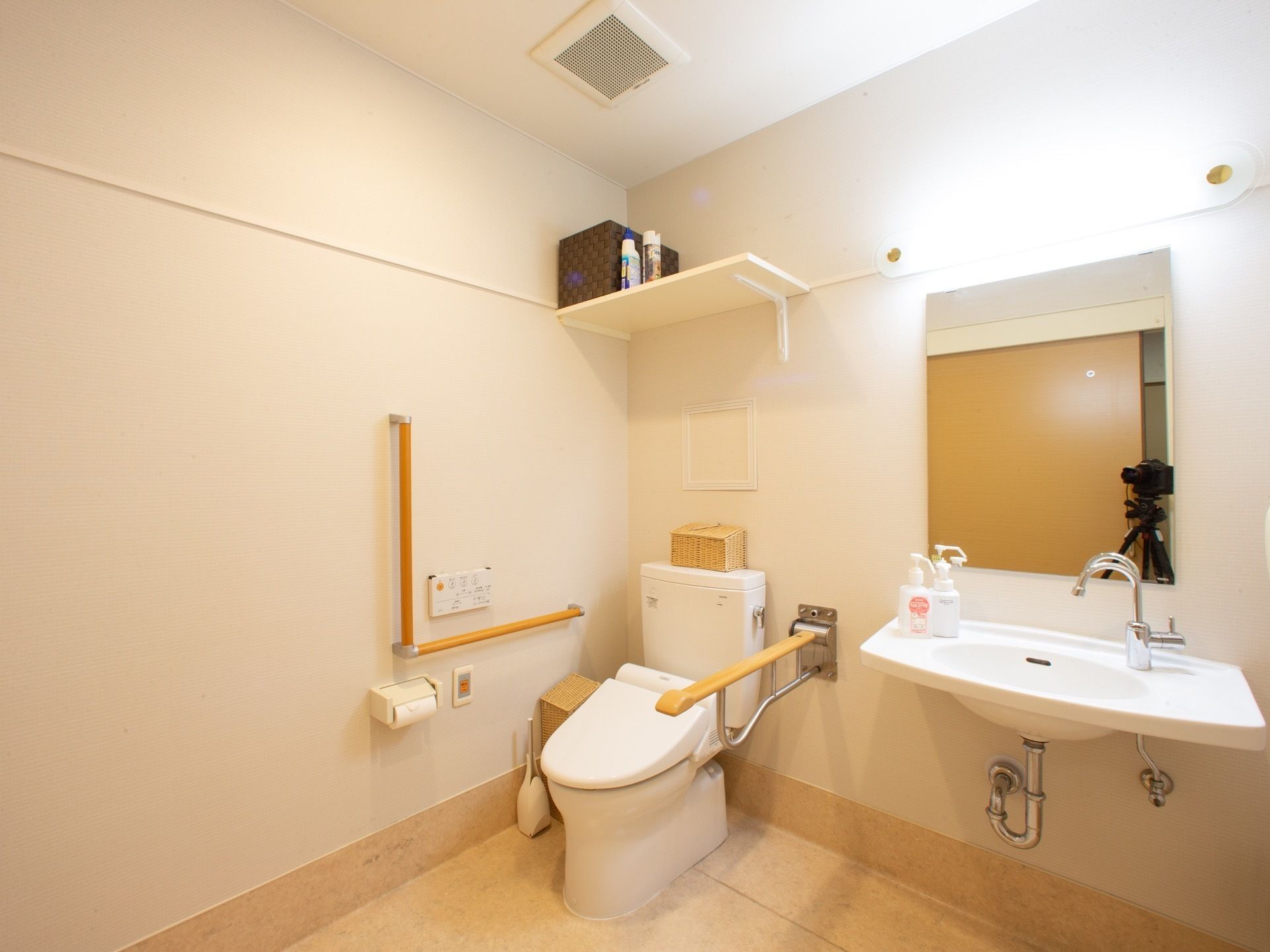 トイレ個室内の奥に設置されている、手すりのついた洋式便器