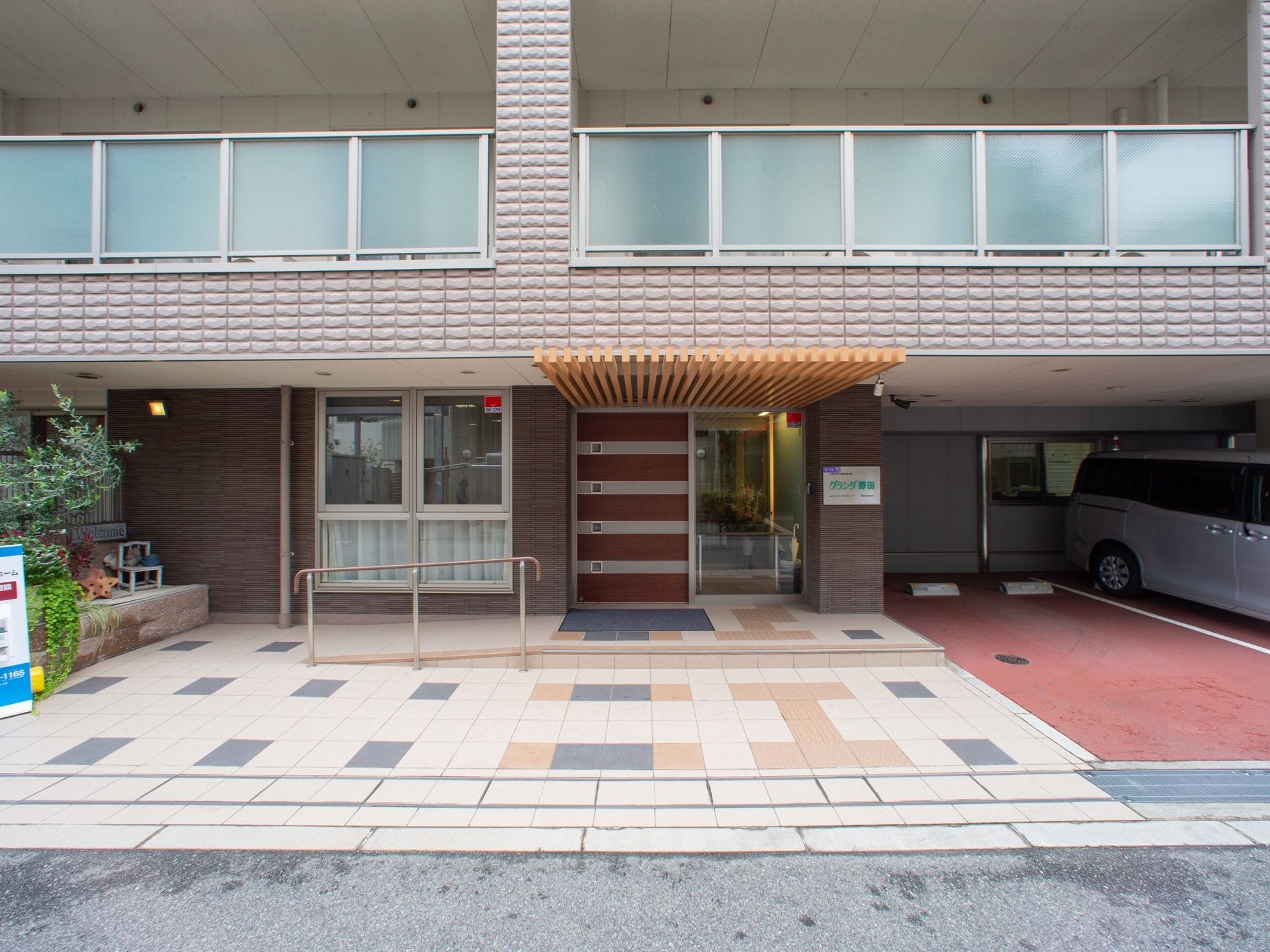 エントランス前に設置された緩やかなスロープと安全手すり
