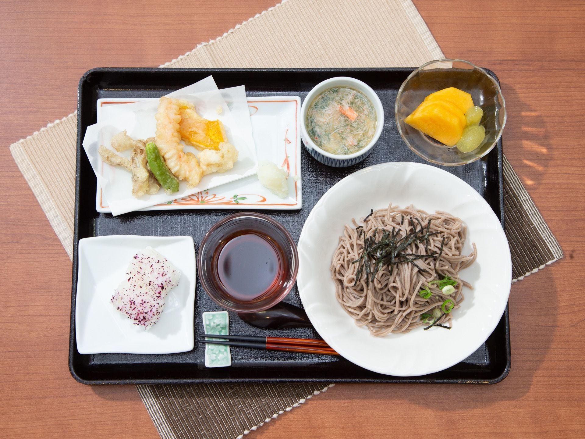 お盆に配膳された、蕎麦や野菜を中心とした天麩羅のついた食事
