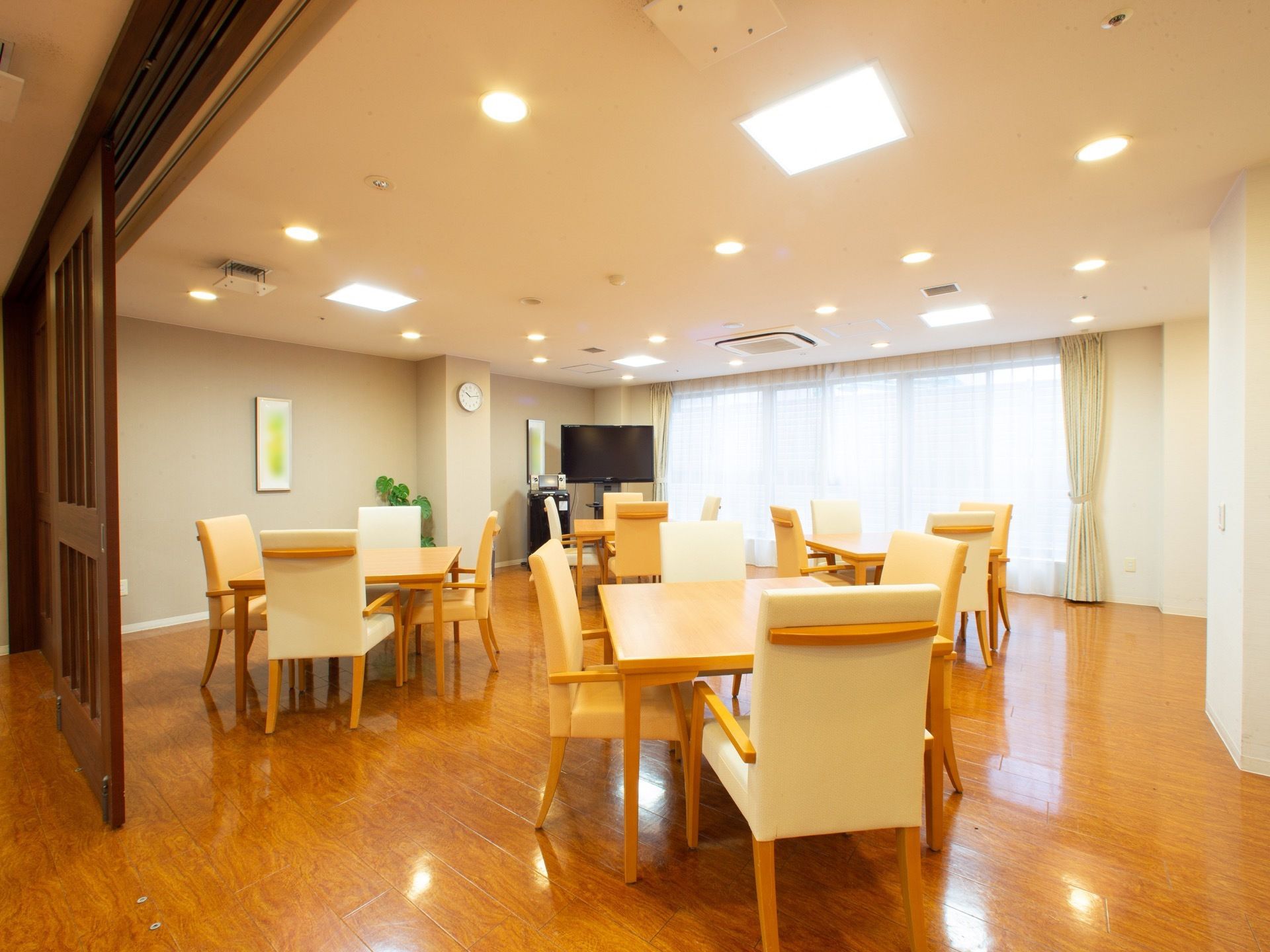 複数のテーブルセットが置かれた部屋にあるカラオケセット