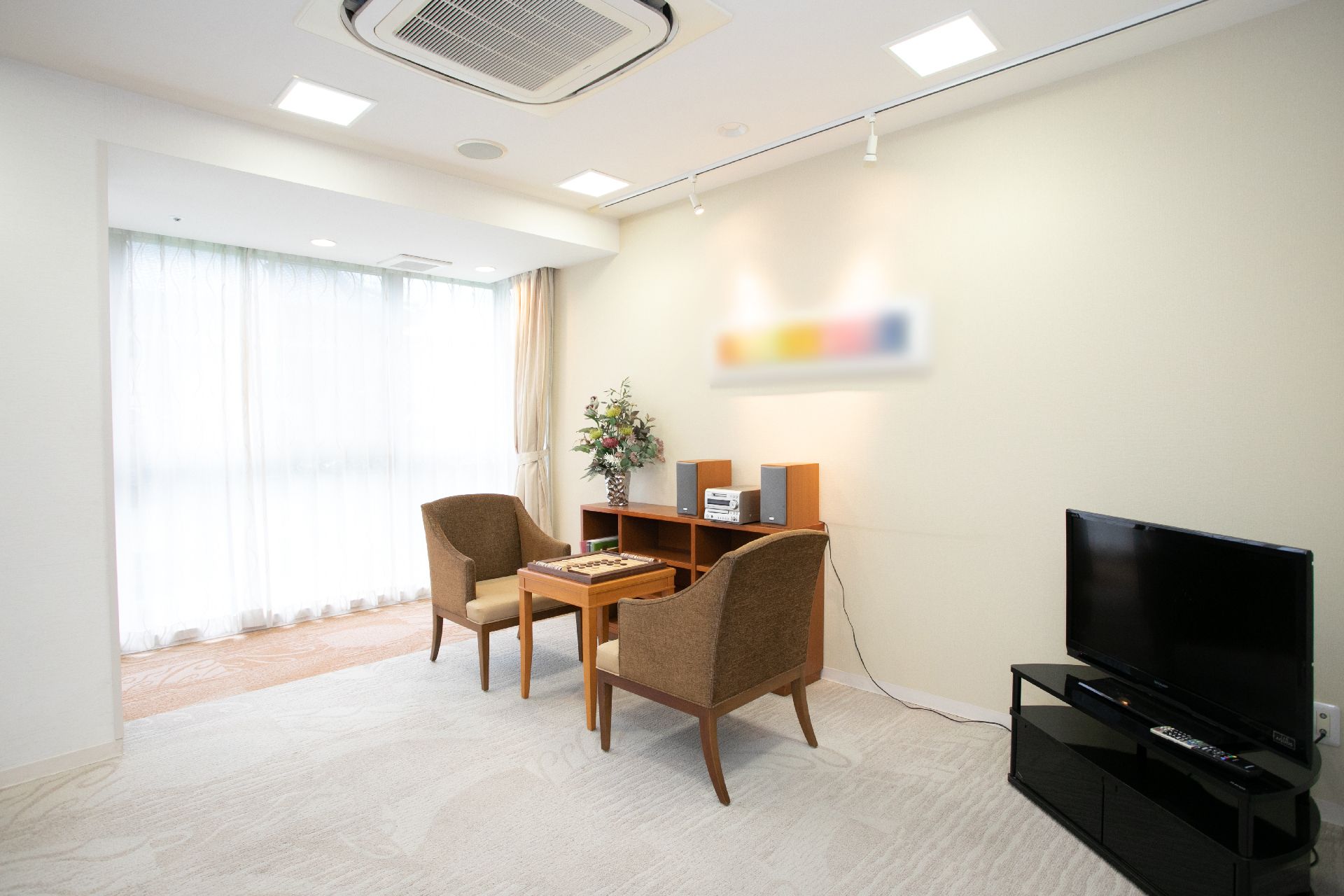 ソファー型の椅子が置かれ、テレビや絵画が設置された共有スペース
