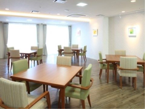 緑の椅子がついたテーブルセットが置かれており、壁に飾られた絵で明るい雰囲気が漂っている。ゆったりとしたスペースがあり、移動も楽にできる。