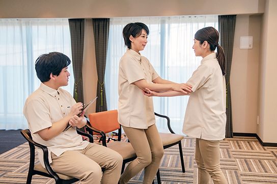 ベッドで上半身だけを起こしている女性と聴診器を使っている女性看護師