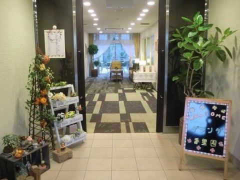 エントランスには観葉植物の鉢植えが置かれ、さまざまな花が咲いたオブジェなどが飾られ賑やかな空間になっている。