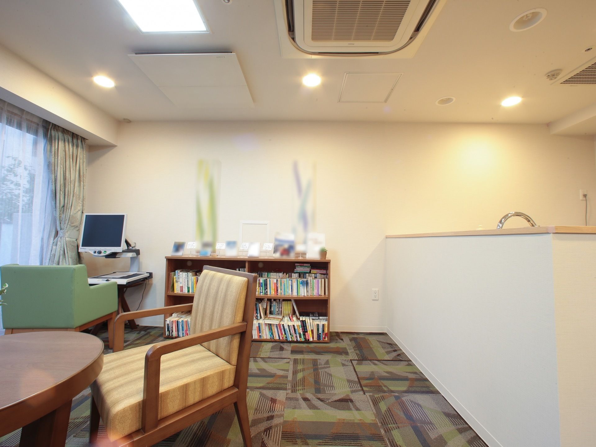 たくさんの本が収納され、壁際に置かれている上下２段の本棚