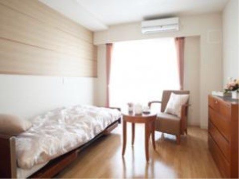 フローリングの床に木をあしらった壁が温かみを感じさせる居室である。くつろいで過ごせるよう家具など自由にレイアウトできる。